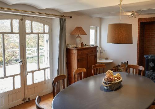 une salle à manger avec une table et des chaises et une fenêtre dans l'établissement Villa Les Cormorans, Vue Mer, 10 personnes, à Ault