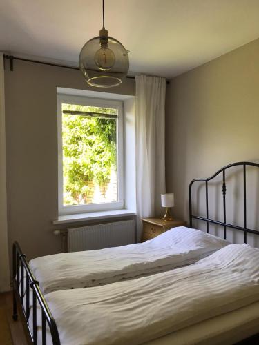 a bedroom with a bed and a window at Seven Sisters Apartments with Self Check-In in Liepāja