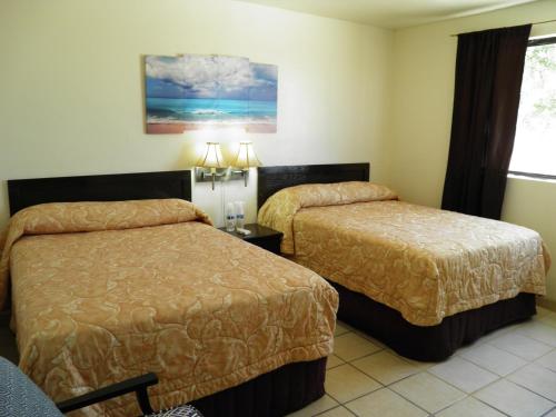Habitación de hotel con 2 camas y ventana en #36 Bungalow Seaside Hotel & Victors RV Park, en San Felipe