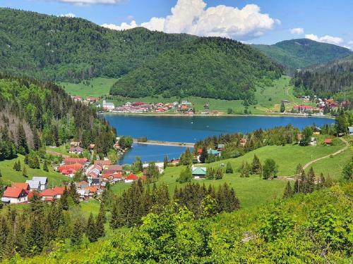 une petite ville dans les montagnes avec un lac dans l'établissement Penzión u Čupku, à Mlynky 