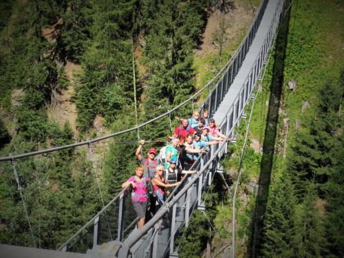 a group of people standing on a suspension bridge at Sport Garni Kapplerhof – Ischgl/Kappl in Kappl