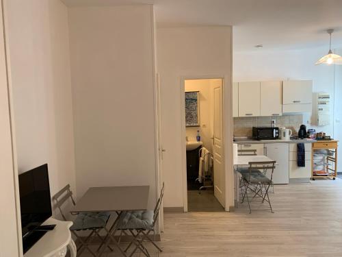 une cuisine et une salle à manger avec une table et des chaises dans l'établissement L'Appartement de la Maison du Théatre Saint Bonnet, à Bourges