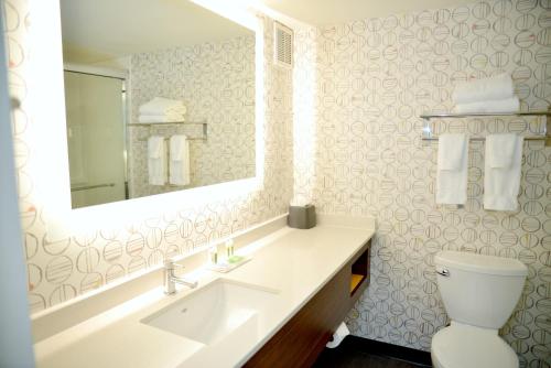 a bathroom with a sink and a mirror and a toilet at Holiday Inn Portland- I-5 S Wilsonville by IHG in Wilsonville