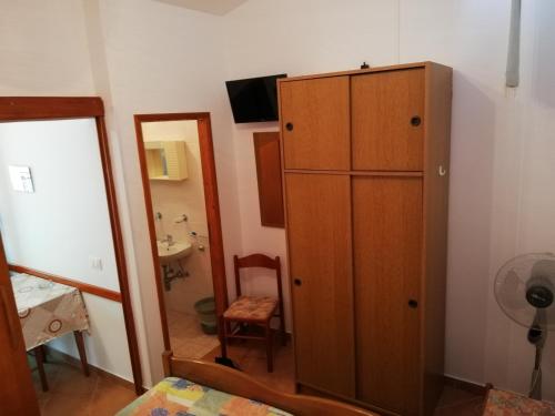 Habitación con armario de madera y espejo. en Apartments Ana Pogana en Punta Križa