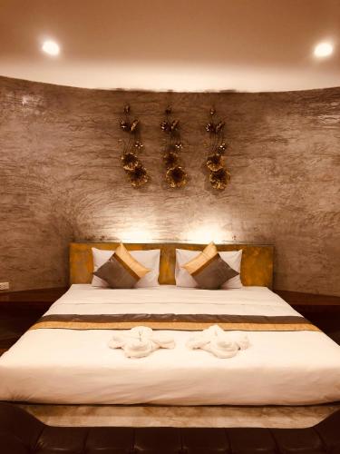 a bedroom with a large bed with white sheets at Nao Ta Chuang in Thung Song