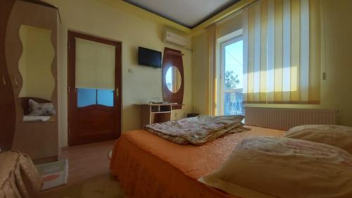 a bedroom with two beds and a large window at Ana si Alex in Eforie Nord