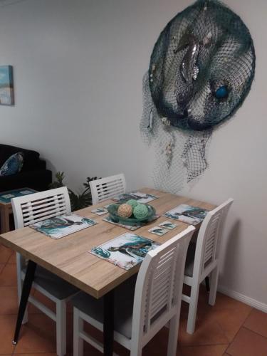 a wooden table with chairs and a hat on the wall at Casa Borghese Holiday Let in Cairns