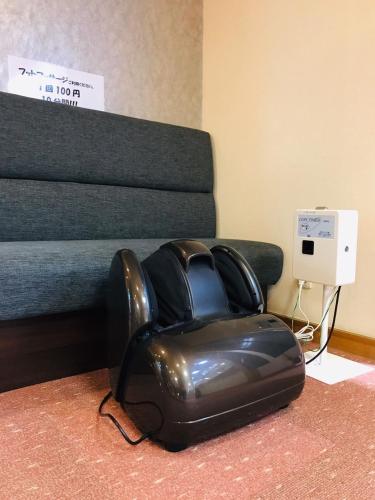 a black leather chair sitting next to a bed at Saigiku in Iwaki