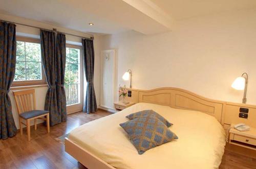 sypialnia z łóżkiem z poduszką w obiekcie Park Hotel Miramonti w mieście San Martino di Castrozza