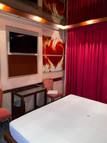a bedroom with a bed and a red curtain at THE CRYSTAL BLUE XAIDARI HOTEL in Skaramangás