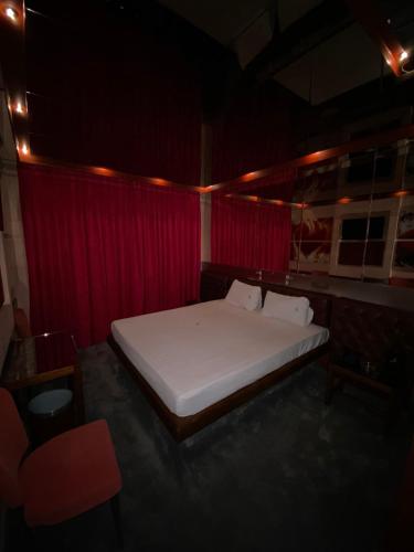 a bedroom with a large bed in a red room at THE CRYSTAL BLUE XAIDARI HOTEL in Skaramangás