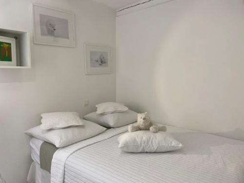 a teddy bear sitting on a bed in a bedroom at La Tanière de l'Ours Blanc Aubagne-Cassis-Aix en Provence in Aubagne