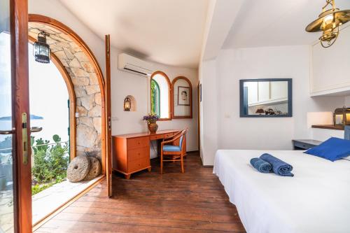 a bedroom with a bed and a desk and a window at Villa Kamen in Blato