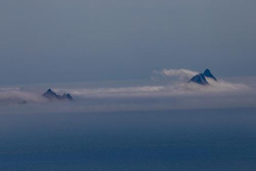 two mountains in the clouds in the sky at Skellig Port Accommodation - 1 Studio Bed Apartment in Portmagee