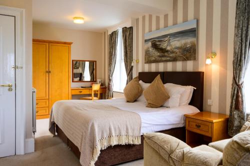 a hotel room with a bed and a couch at The White House Inn - Whitby in Whitby