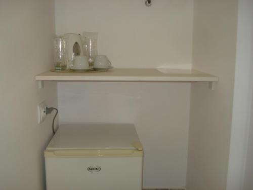 a shelf on top of a toilet in a bathroom at Kupenova Guest House in Sozopol