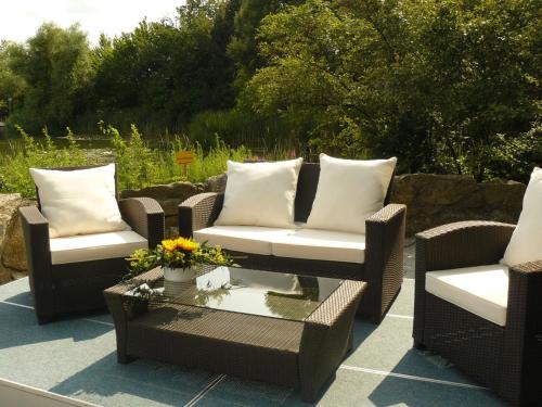 a group of wicker chairs and a table on a patio at Atrium im Park Hotel Regensburg in Regensburg