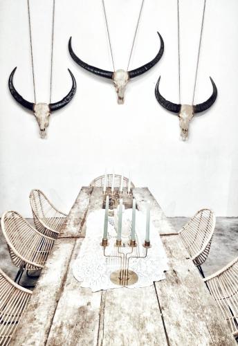 a dining room with a table with horns on the wall at Lambo Homestay in Waikabubak
