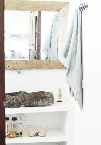 a mirror on a shelf in a bathroom at Lambo Homestay in Waikabubak
