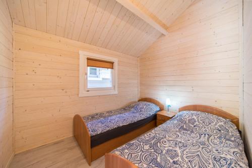 a small room with two beds in a cabin at Domki nad morzem WOJTAS in Wrzosowo