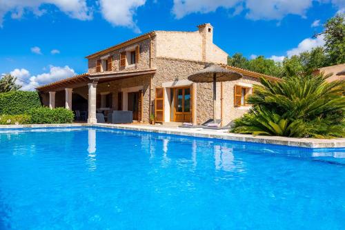 a villa with a swimming pool in front of a house at Cas Batlet Antonia in S'Horta