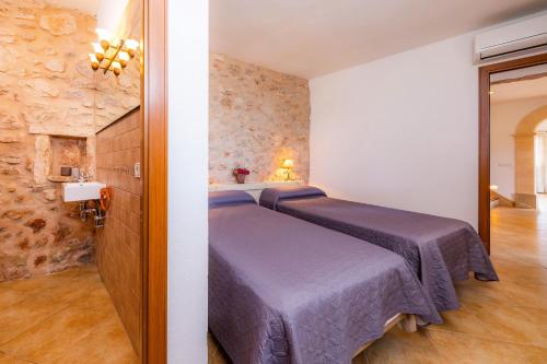 a bedroom with two beds in a room at Cas Batlet Antonia in S'Horta