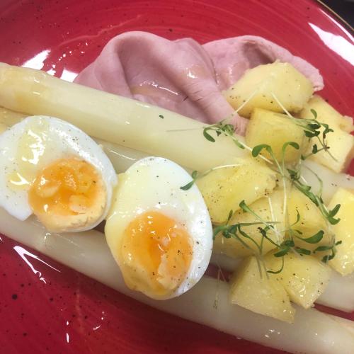 a plate of eggs and potatoes on a red plate at Hotel Crasborn Thorn in Thorn