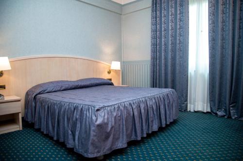 Un pat sau paturi într-o cameră la Aldero Hotel