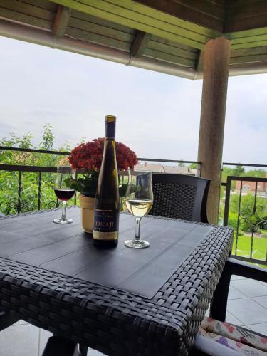 a bottle of wine sitting on a table with wine glasses at Harmónia Vendégház in Balatonalmádi