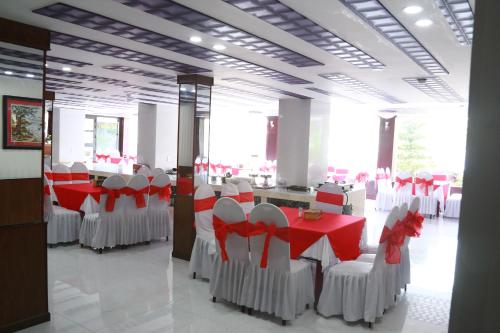 a dining room with red and white chairs and tables at KHÁCH SẠN SAO MAI in Cao Lãnh