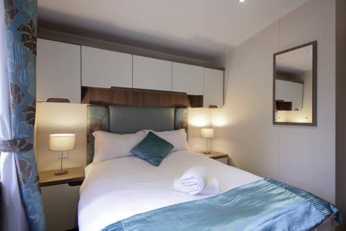 a bedroom with a bed with two towels on it at Edinburgh - Seton Sands-Cameo Caravan-Pet Friendly in Edinburgh