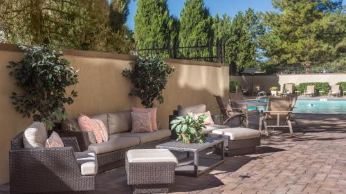 a patio with a couch and chairs next to a pool at Holiday Inn Denver Lakewood by IHG in Lakewood
