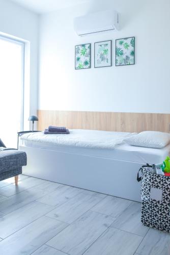 a white bedroom with a large white bed at Apartamenty Pawełek in Zator