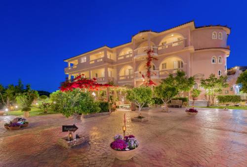 un grand bâtiment avec des arbres devant lui dans l'établissement Filoxenia Luxury Studios & Apartments, à Zante