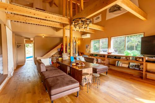 sala de estar amplia con mesa y sofá en YOISAMA Sunset Beach House, en Ishigaki Island