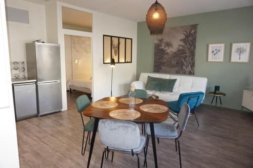 un salon avec une table, des chaises et un canapé dans l'établissement L'Eucalyptus, charmant T2 au cœur du centre ville, à Rennes
