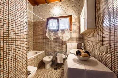 a bathroom with a sink and a toilet and a tub at Tortuga Casa Vacanze in Scarlino