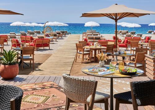 a restaurant on the beach with tables and chairs at Hôtel Barrière Le Gray d'Albion in Cannes