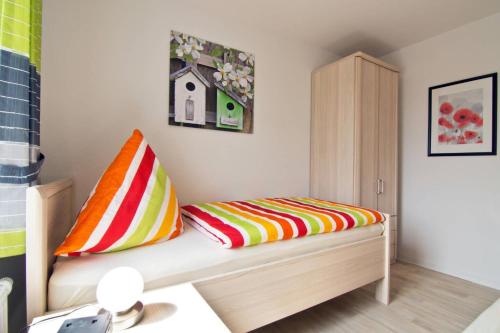 ドルヌマージールにあるFerienwohnung Annegretのカラフルな枕が置かれたベンチが備わる客室です。