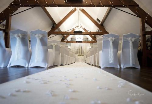 una fila de vestidos y zapatos de boda blancos en una habitación en The Barns Hotel, en Cannock