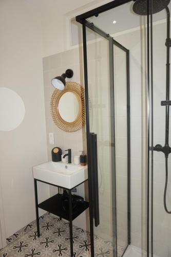 une salle de bain avec un lavabo et un miroir dans l'établissement L'Eucalyptus, charmant T2 au cœur du centre ville, à Rennes