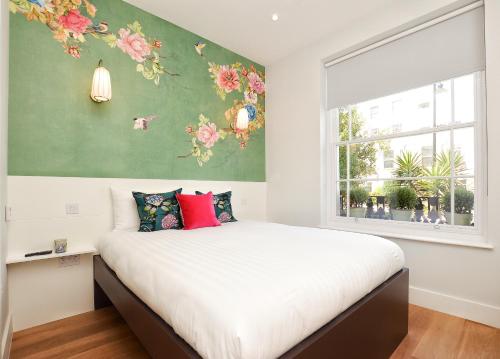 a bedroom with a large bed with flowers on the wall at StayPrime Notting Hill Serviced Apartments in London