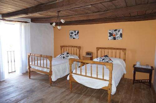 2 Betten in einem Zimmer mit Holzböden in der Unterkunft Los Polvazares in Castrillo De Los Polvazares