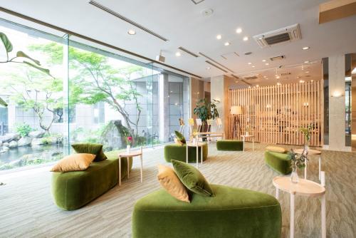 vestíbulo con muebles verdes y ventanas grandes en Yutoriro Bandai Atami en Koriyama