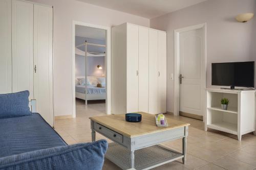 a living room with a couch and a tv at ASTRA Village Resort in Svoronata