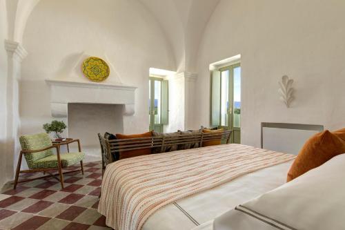 a bedroom with a large bed and a fireplace at Rocco Forte Masseria Torre Maizza in Savelletri di Fasano
