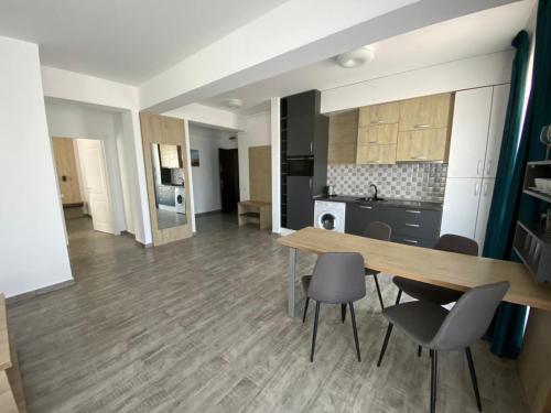 a kitchen and dining room with a table and chairs at Apartament Ella C&C Residence in Mamaia Sat/Năvodari