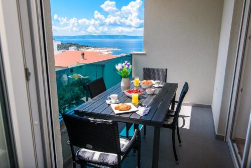 a table with food on it on a balcony at Lorena Luxury Apartment in Makarska