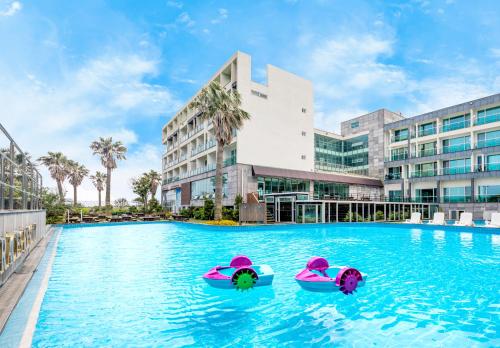uma piscina num hotel com dois insufláveis na água em The Four Grace Resort em Seogwipo
