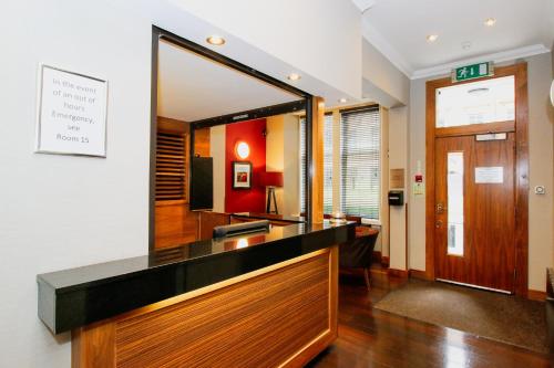 a bathroom with a mirror on the wall and a sink at Kelvingrove Hotel - Sauchiehall St in Glasgow